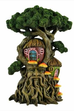 a tree stump with a house on it and mushrooms growing out of the trees around it