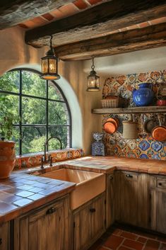 a kitchen with an arched window and tile counter tops on either side of the sink