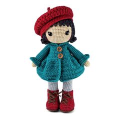 a crocheted doll is wearing a red hat and blue coat with buttons on it