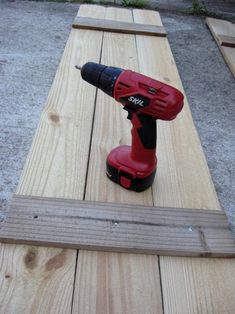 a cordless driller is sitting on top of a wooden plank