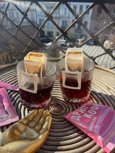 there are two glasses with drinks on the table