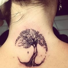 a woman's back neck with a tree tattoo on her left side ribcage