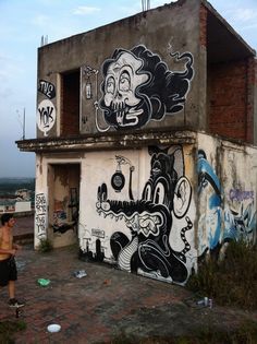 a man standing in front of a building with graffiti on it