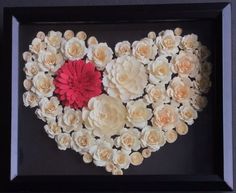 a heart made out of flowers in a black frame