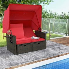 a red couch sitting next to a swimming pool