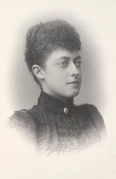 an old black and white photo of a woman with short hair wearing a collared shirt