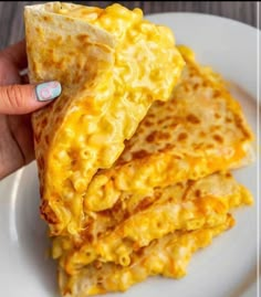 a person holding up some food on a plate