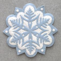 a blue and white snowflake on a gray surface