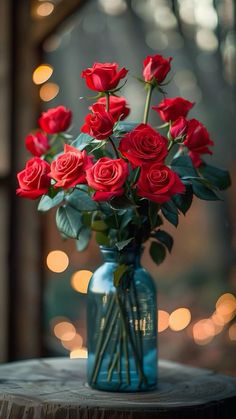 a vase filled with red roses sitting on top of a table