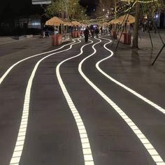 an empty street with white lights on it