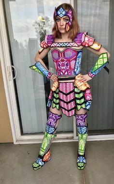 a woman dressed in colorful clothing standing next to a window