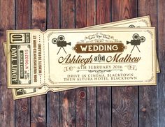 two tickets sitting on top of a wooden table next to each other with the words wedding