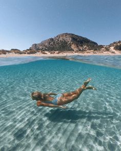 a woman is floating in the clear blue water