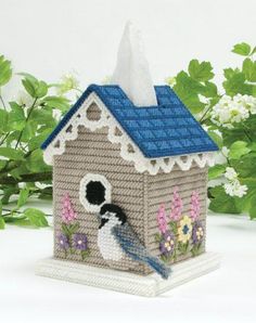 a small birdhouse with a blue roof and white trim on it's side