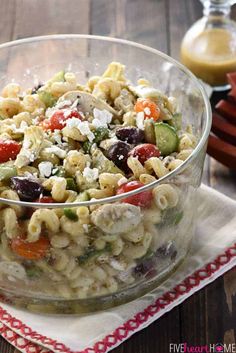 a bowl filled with pasta salad on top of a red and white napkin