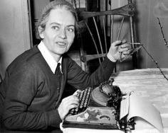 a woman sitting at a table with an old typewriter