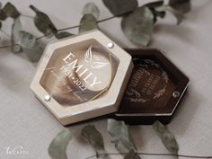 an empty wooden box sitting on top of a table next to some leaves and flowers