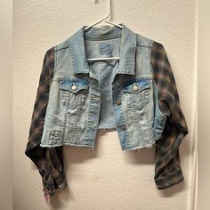 an old jean jacket hanging on a wall