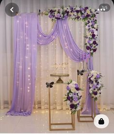 the wedding arch is decorated with purple and white flowers, along with other floral arrangements