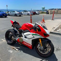 a red and white motorcycle parked in a parking lot