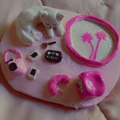 there is a pink tray with various items on it that include a cat, dog and palm tree