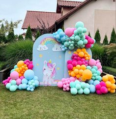 an inflatable unicorn house with balloons on the lawn