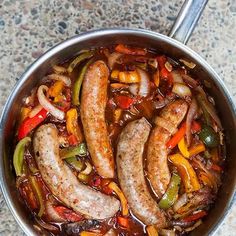 sausages and peppers are cooking in a pan