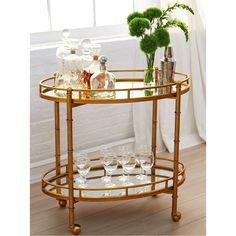 a gold bar cart with wine glasses on it