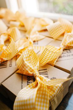 several boxes wrapped in yellow and white checkered paper, tied together with ribbon bows