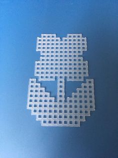 four pieces of white plastic on a blue surface with one piece cut out to look like a cross