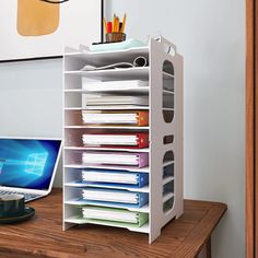 a laptop computer sitting on top of a desk next to a stack of folders