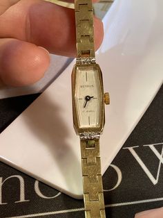 "Excellent working and very good cosmetic condition. 4-Diamond Bezel. Gold tone base metal bezel and stainless steel back case. Comes with a I.D. Hong Kong gold tone metal bracelet. Case size measures 10.4mm x 27.3mm. Wrist size is approximately 6.25\" inches." Rare Vintage Watches Bye Jemis, Luxury Heirloom Watches For Women, Cheap Rectangular Dial Jewelry Gift, Luxury Antique Watch Accessories, Vintage Gold Watch Swisswatchexpo, Retro Watches Vintage, 1970s Bands, Pretty Watches, Retro Watches