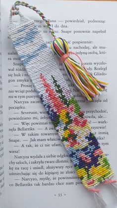 a bookmark made out of beads and thread with tassels on the end