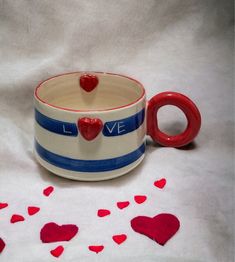 a ceramic cup with red hearts on it