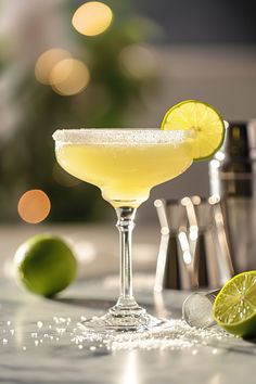 a margarita sitting on top of a table next to limes