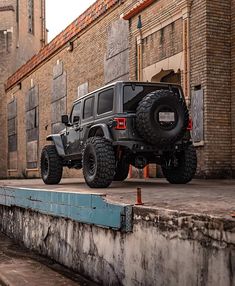 a black jeep parked in front of an old brick building