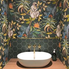 a bathroom with a sink and wallpaper on the walls, along with a wooden countertop