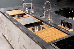 a kitchen with two sinks and wooden cutting boards