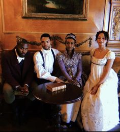 three people are sitting on a couch in front of a table with a book on it