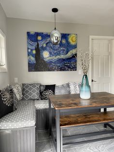 a living room filled with furniture and a painting on the wall above it's coffee table