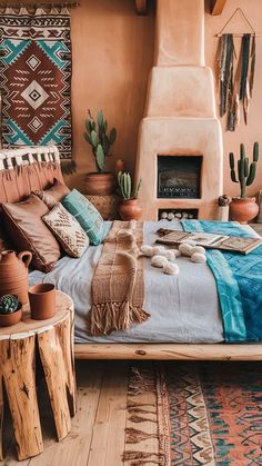 a bed with pillows and blankets on it in front of a fireplace surrounded by potted cacti