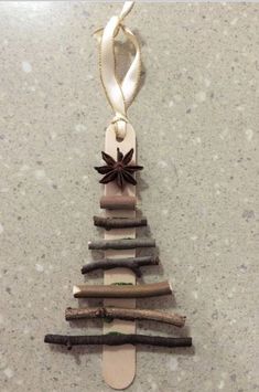 a christmas tree made out of driftwood sticks with an ornament hanging from the top