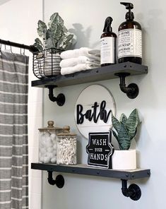 the bathroom is decorated in black and white with lots of items on shelves above it