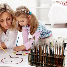 a mother and daughter doing art at the table