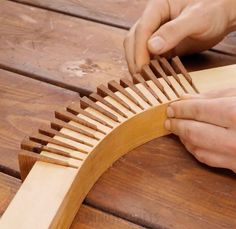 a person using a wooden brush to clean a piece of wood