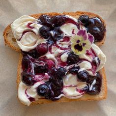 a piece of bread with blueberries and cream on it