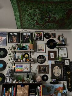 there are many pictures on the wall above the bookshelf and shelves with records