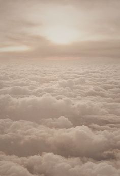 the view from an airplane looking down on some clouds