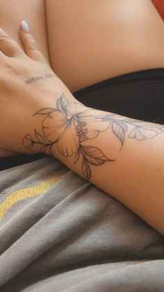 a woman's arm with a flower tattoo on the left side of her body