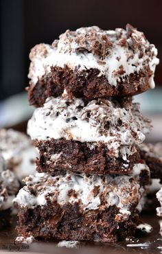 three chocolate brownies with white frosting stacked on top of each other